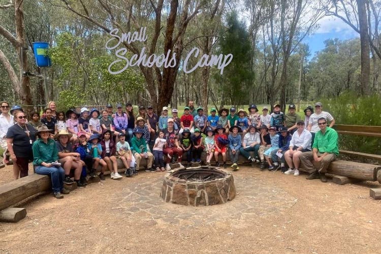 Our students participated with several other small schools at a camp this year, this image shows all of the campers sitting around an unlit fire pit, a koala tree trough is in the background.